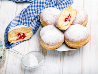 Traditional Polish donuts on wooden background.  Tasty doughnuts with jam.