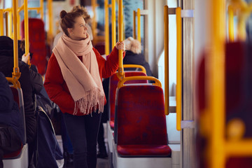 Young pretty girl stand in the tramway and look at window