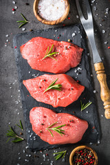 Beef steak with rosemary and spices on black background