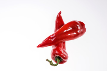 Two fresh red bell peppers isolated on a light background