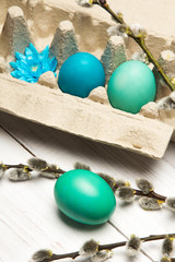 Easter background with eggs and catkins on white wooden background, copy space