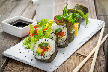 healthy kale and avocado sushi roll with chopsticks