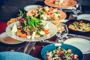 many different dishes in Restaurant, white plate on the Table with side dish,