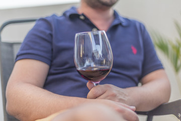 Man hand picks up wine glass