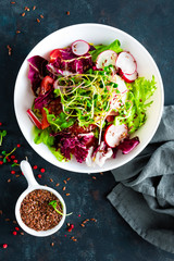 Fresh vegetable salad plate of tomatoes, italian mix, pepper, radish, green sprouts and flax seeds. Vegetarian dish, healthy food. Diet breakfast, lunch or dinner menu. Salad plate on tablу