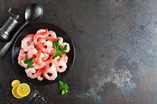 Prawns on plate. Shrimps, prawns. Seafood. Top view. Dark background