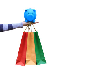 Saving money for shopping and investment concept, young woman holding blue piggy and shopping bags on white background