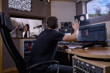Singer recording a musical theme, in a recording studio