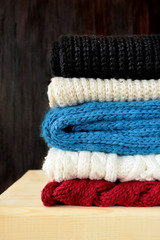 Obraz na płótnie Canvas Knitted scarves of different colours are piled carefully