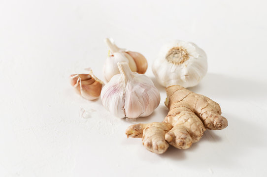 Garlic heads and ginger root on white background