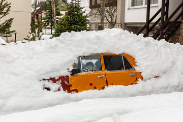 Car parking under under a pile of snow