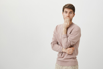 Indoor portrait of cute and handsome adult man with bristle standing in surprised or astonished...