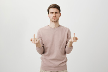 Portrait of handsome and stylish european guy expressing negative emotions, being angry and showing...