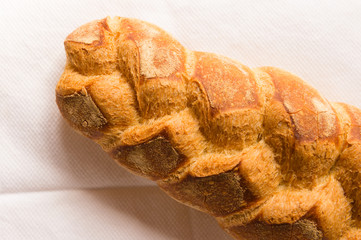 Homemade bread resting on a white cloth with natural light.