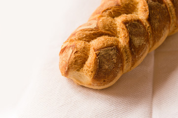Homemade bread resting on a white cloth with natural light.