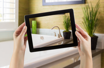 Female Hands Holding Computer Tablet In Bathroom with Photo on Screen. © Andy Dean