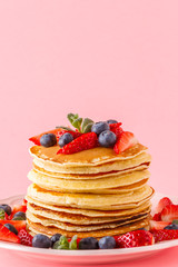 Pancakes with berries on a bright pastel background
