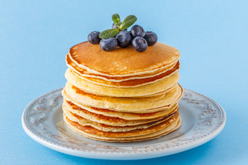 Pancakes with berries on a bright pastel background