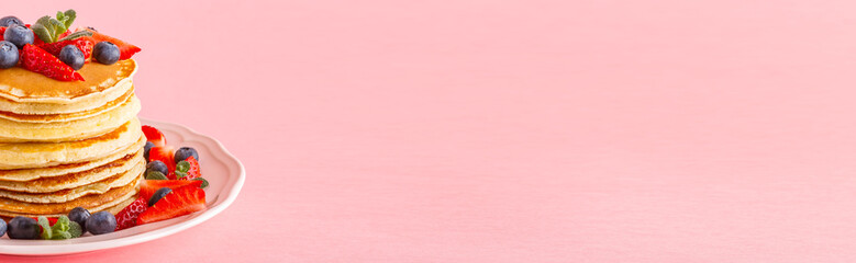 Pancakes with berries on a bright pastel background