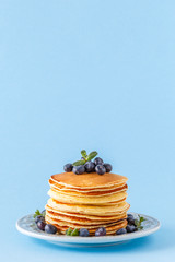 Pancakes with berries on a bright pastel background