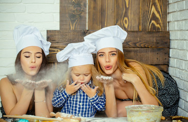 Women and child blowing flour