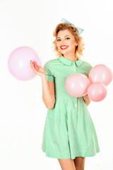 Pinup girl in dress poses with balloon