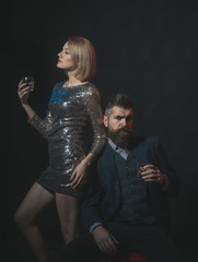 Man and woman in fancy clothes drink wiskey