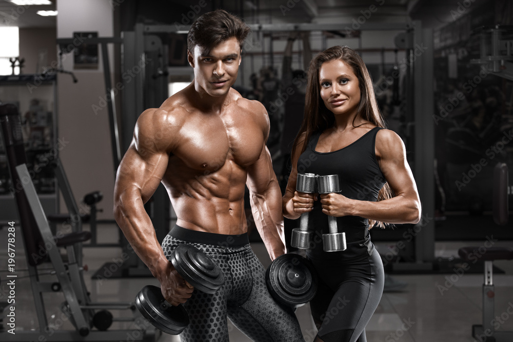 Wall mural sporty sexy couple showing muscle and workout in gym. muscular man and woman