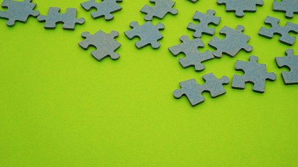 Bunch of scattered pieces of a puzzle isolated on a green background