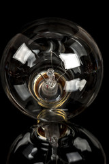 Close up of an old incandescent light bulb that is clear see through
