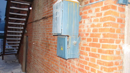 The electrical panel on a brick wall.