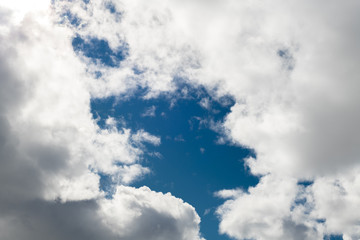 White puffy clouds with blue sky in the middle
