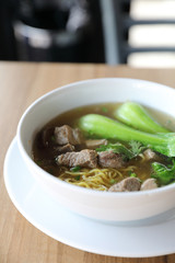 Chinese noodles with pork on wood background