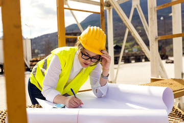 Confident Female Engineer or Architect Working at Construction Plan