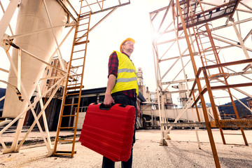 Fototapeta premium Young construction worker with tool box