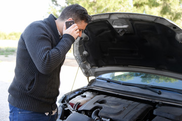 man calling by phone with broken down car