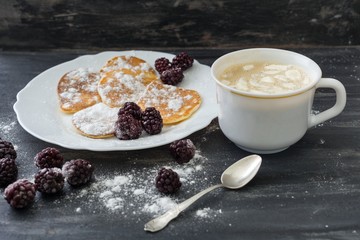 Tasty american pancakes with blackberries, powdered sugar, coffee with marshmallow.