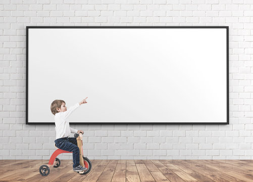 Cute boy on a tricycle, showing finger whiteboard