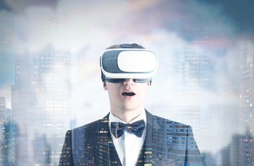 Fototapeta premium Astonished man in VR glasses, gray city