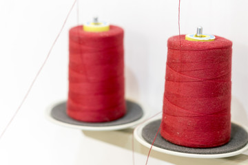 Two red thread coils. Threads for industrial sewing machines
