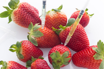 Modified food concept / strawberries with punched needles and syringes