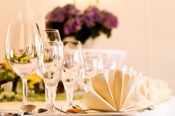 Festliches Tisch-Arrangement mit Gläser und Servierten und Blumen