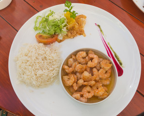 Close up tasty fried pink shrimps cooked with garlic or prawns seasoned with olive oil and herbs served as rice cooked a seafood starter on plate