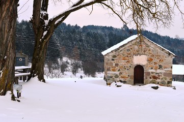 an old stone church in the snow
