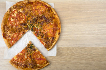 Harmful and ugly pizza on a wooden table. Copy Space