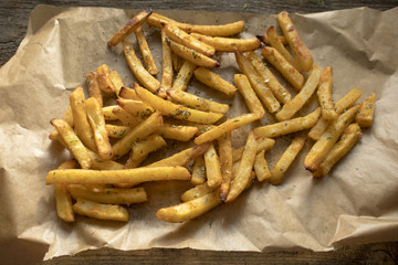 French fries on paper, On an old wooden surface.