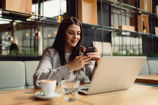Woman at the cafeteria using mobile phone