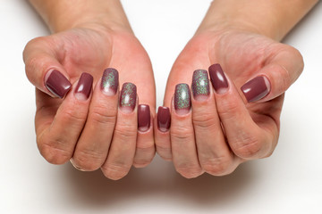 beige manicure dior with sequins on long square nails on a white background on tanned hands
