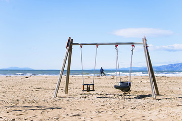 background wooden swing on the beach