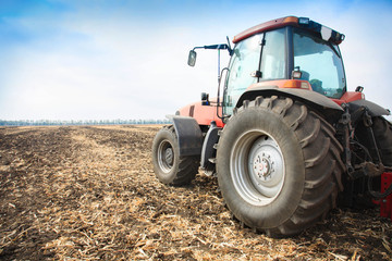 Obraz premium Modern red tractor in the field.